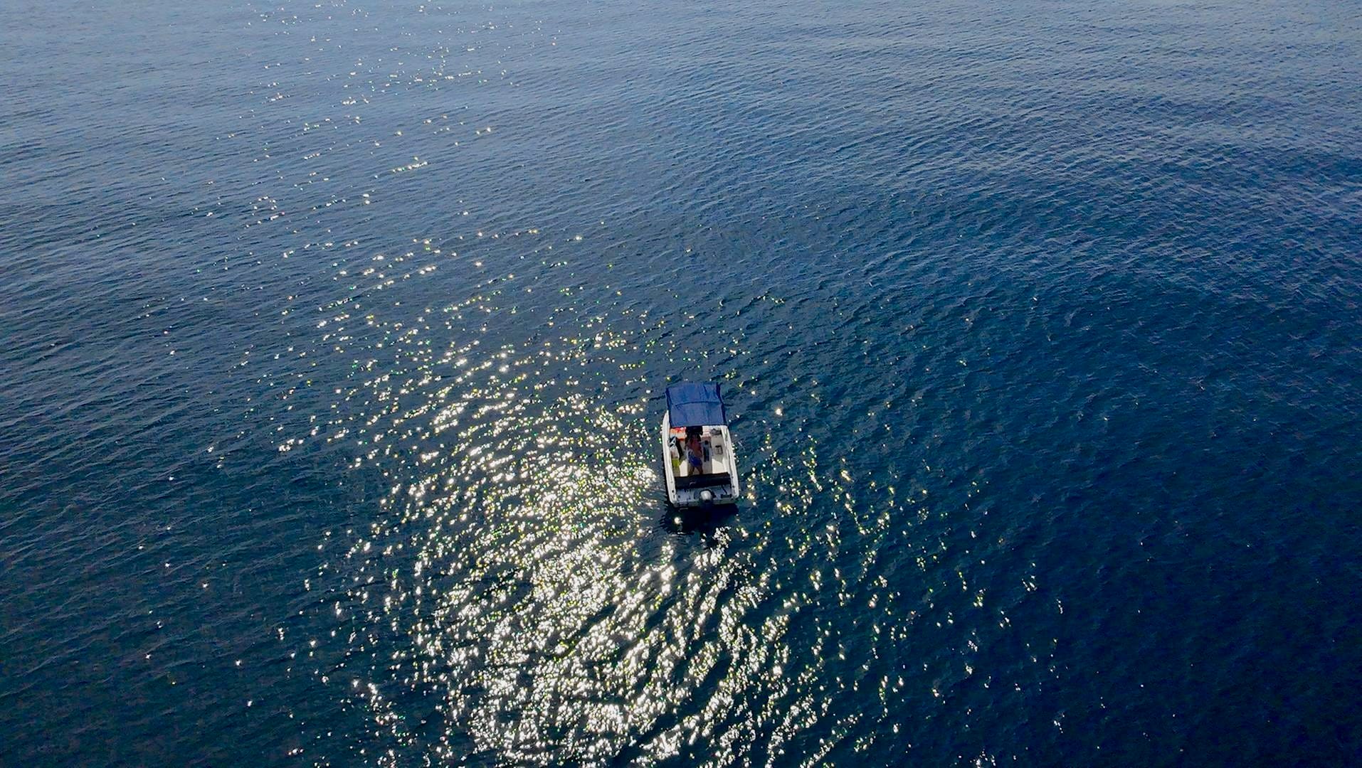 Barco navegando frente a la costa de Ksamil, Albania